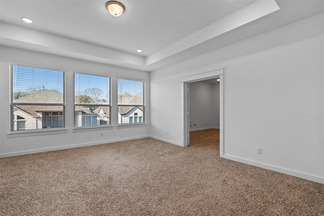 empty room featuring carpet floors and a tray ceiling