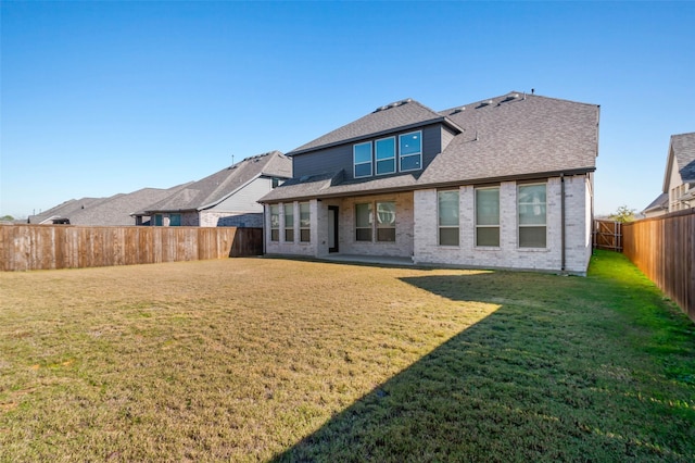 rear view of property featuring a lawn