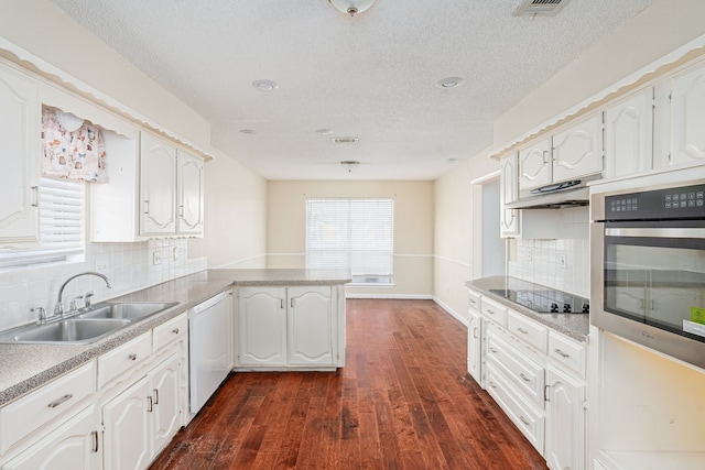 kitchen with dishwasher, white cabinets, oven, sink, and kitchen peninsula