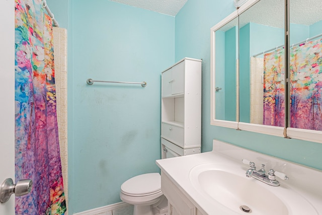 bathroom featuring vanity, a textured ceiling, and toilet