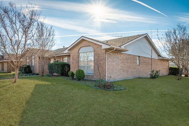 view of side of home with a yard