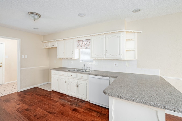 kitchen featuring dishwasher, white cabinets, sink, dark hardwood / wood-style floors, and kitchen peninsula