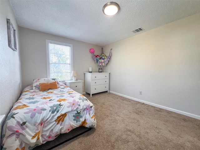 bedroom featuring a textured ceiling and carpet flooring