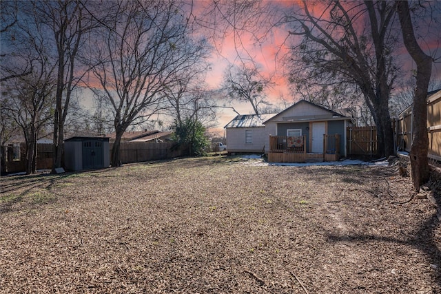 yard at dusk featuring a storage unit