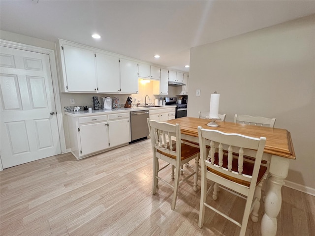 kitchen with white cabinetry, stainless steel appliances, light hardwood / wood-style floors, and sink