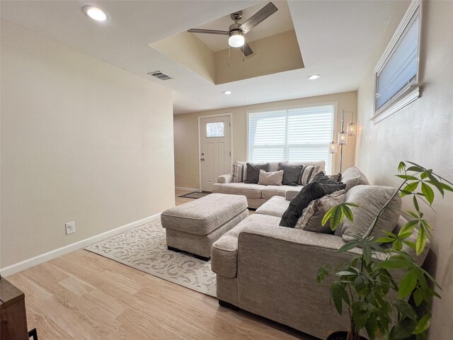 clothes washing area with light wood-type flooring, independent washer and dryer, and water heater