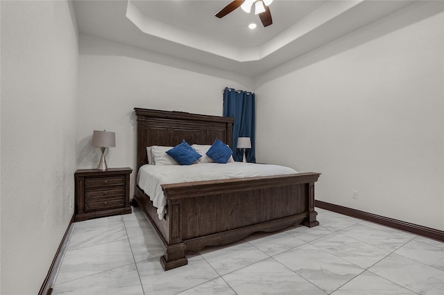 bedroom with a tray ceiling and ceiling fan