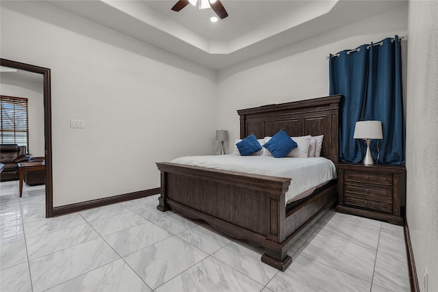 bedroom featuring ceiling fan and a raised ceiling