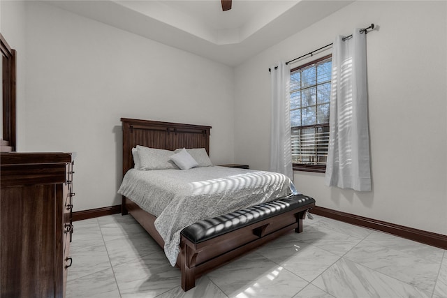 bedroom with a raised ceiling and ceiling fan