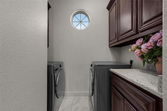 laundry area featuring washer and clothes dryer and cabinets