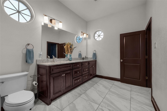 bathroom featuring vanity, toilet, and plenty of natural light