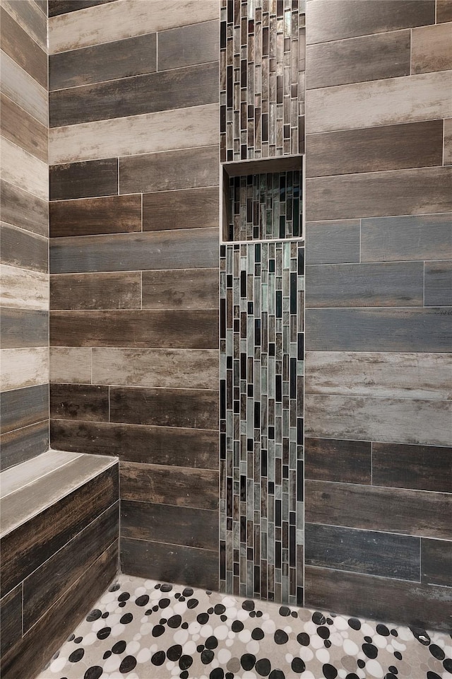 bathroom with wood walls and walk in shower