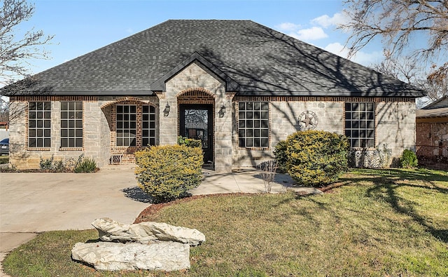 french provincial home featuring a front yard