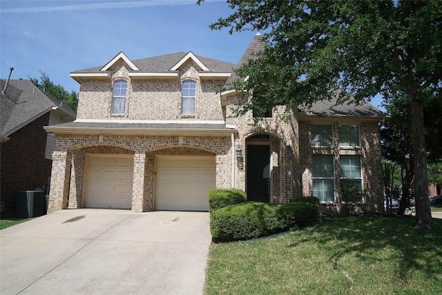 view of front of house with cooling unit, a front yard, and a garage