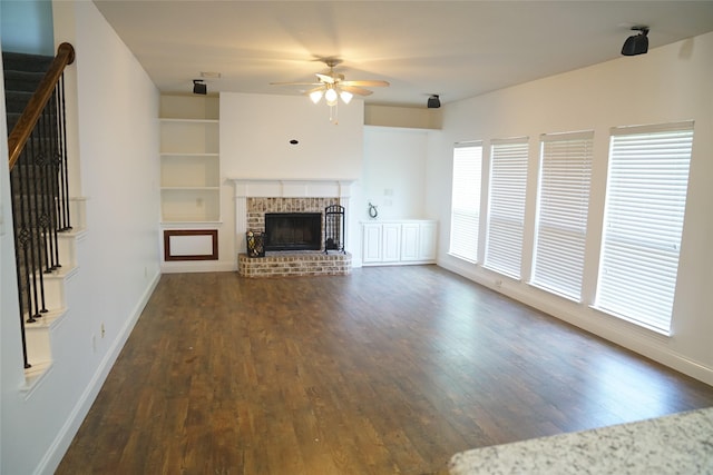 unfurnished living room with ceiling fan, dark hardwood / wood-style floors, and a fireplace