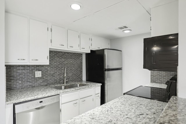 kitchen featuring sink, white cabinets, backsplash, light stone counters, and stainless steel appliances