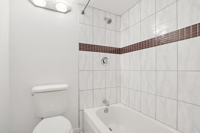 bathroom with tiled shower / bath and toilet