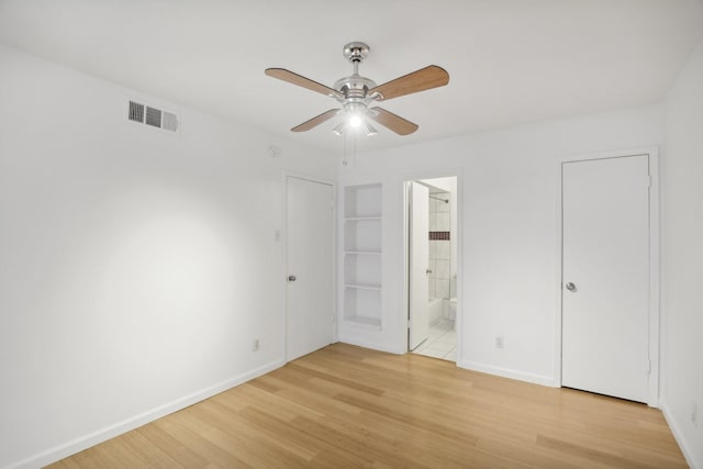 unfurnished bedroom with light wood-type flooring, ceiling fan, and ensuite bath