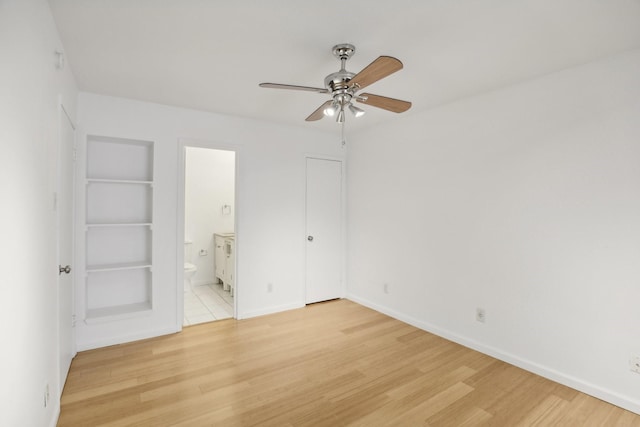 unfurnished bedroom with ceiling fan, ensuite bathroom, and light wood-type flooring