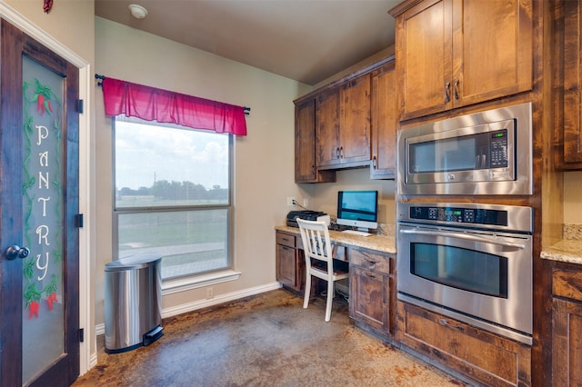 kitchen featuring appliances with stainless steel finishes and light stone counters