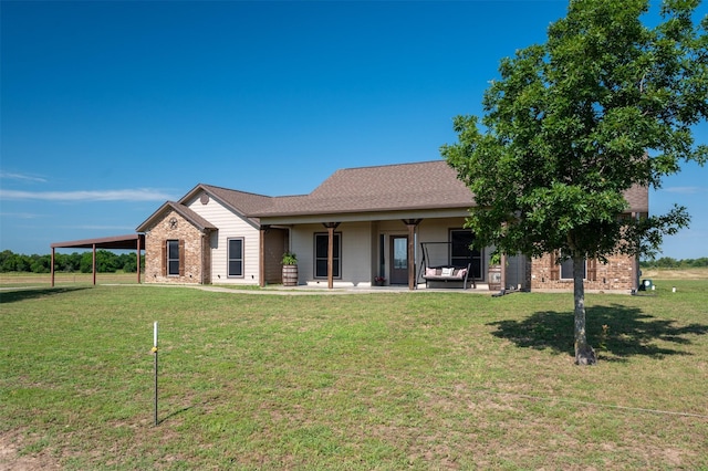 view of front of house with a carport, an outdoor living space, and a front lawn