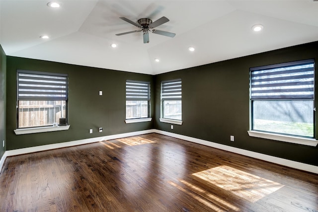 spare room with ceiling fan, plenty of natural light, wood-type flooring, and vaulted ceiling