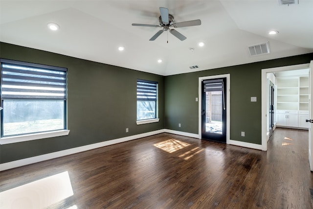 spare room featuring dark wood-type flooring, built in features, ceiling fan, and lofted ceiling