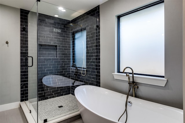 bathroom with tile patterned floors and shower with separate bathtub