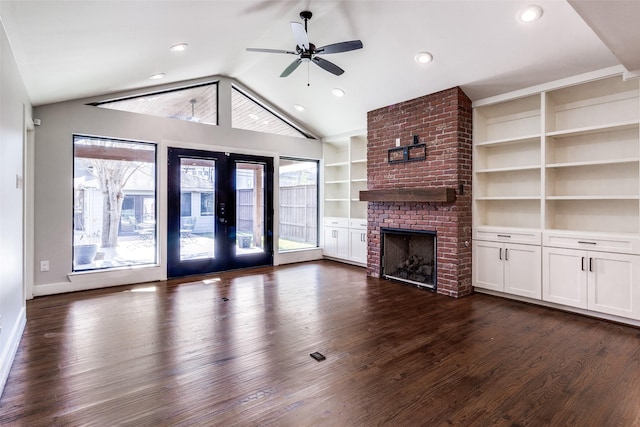 unfurnished living room featuring french doors, ceiling fan, a fireplace, and plenty of natural light