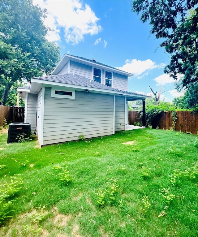 back of property featuring a yard and central air condition unit