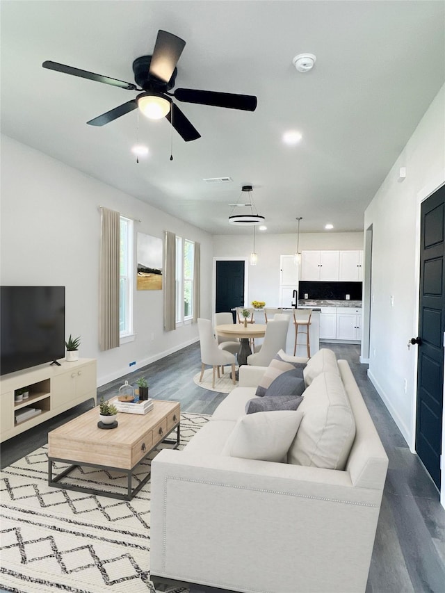 living room featuring ceiling fan and hardwood / wood-style floors