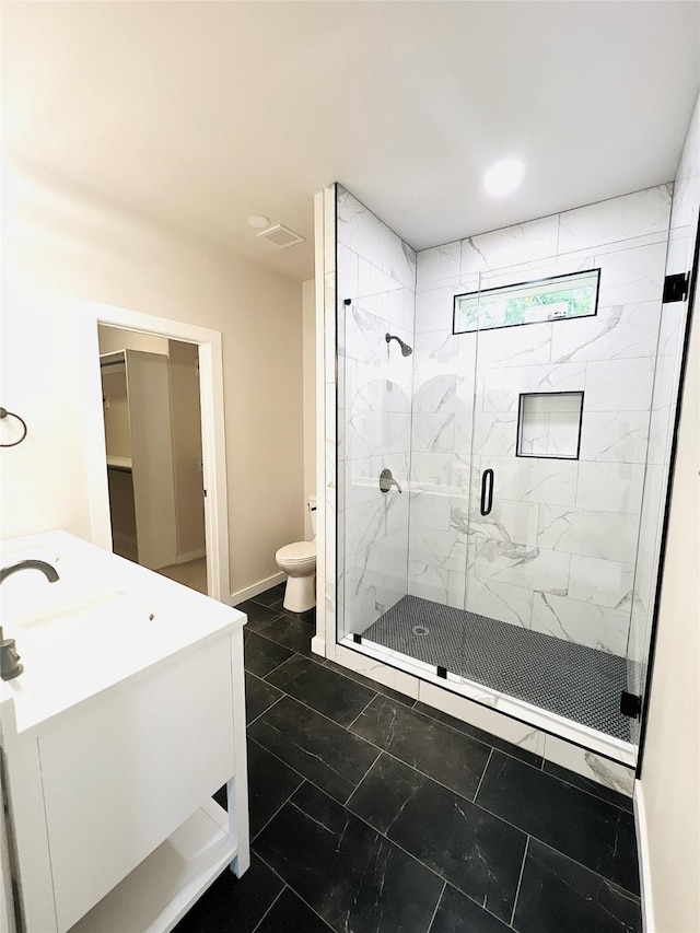 bathroom featuring vanity, toilet, and a shower with door