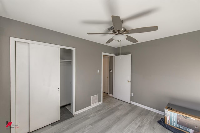 unfurnished bedroom featuring a closet, light hardwood / wood-style flooring, and ceiling fan