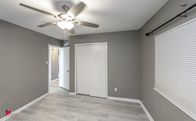 unfurnished bedroom featuring ceiling fan, a closet, and light wood-type flooring