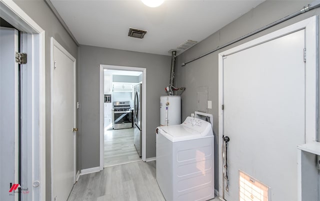 washroom featuring gas water heater, washer / clothes dryer, and light hardwood / wood-style flooring