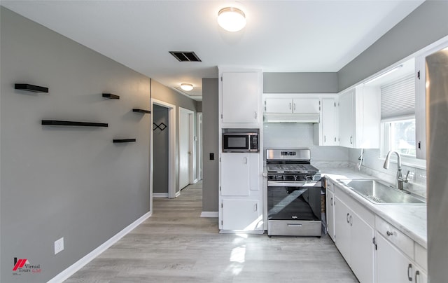 kitchen featuring white cabinetry, decorative backsplash, stainless steel range with gas cooktop, and sink