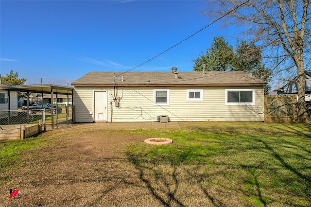 rear view of house featuring a lawn and a fire pit