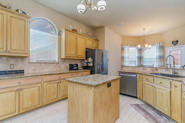 kitchen with sink, a chandelier, hanging light fixtures, appliances with stainless steel finishes, and a kitchen island