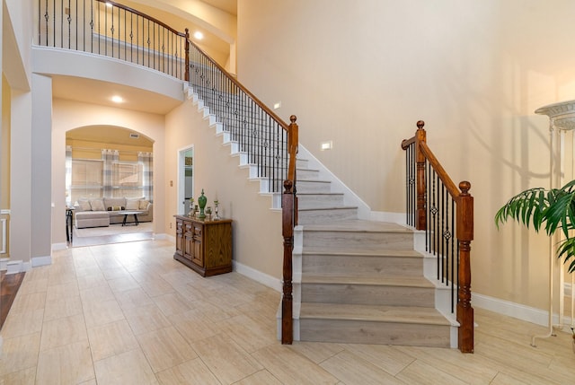 stairway featuring a towering ceiling