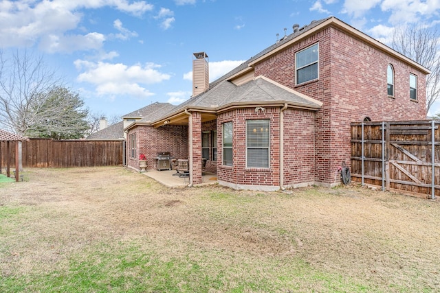 back of property featuring a lawn and a patio