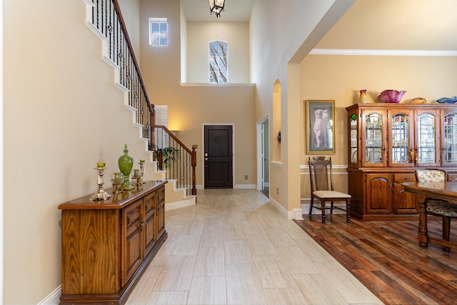 foyer entrance with light hardwood / wood-style floors and a high ceiling