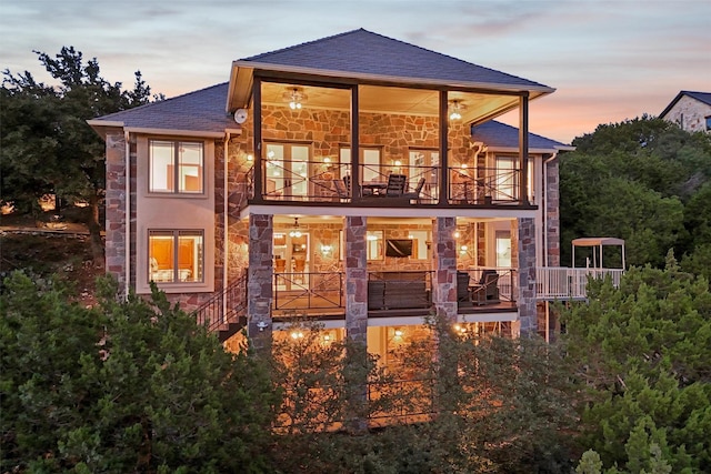 back house at dusk featuring a balcony