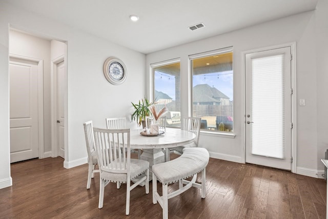 dining space with visible vents, baseboards, and wood finished floors