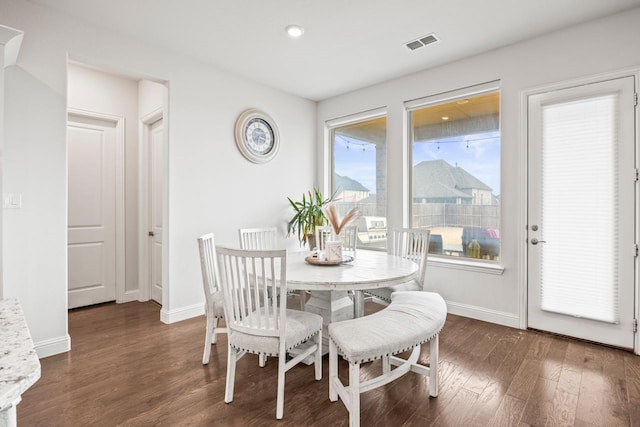 dining space with visible vents, dark wood finished floors, and baseboards