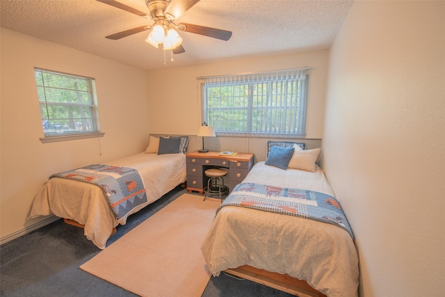 carpeted bedroom with ceiling fan and a textured ceiling