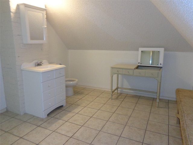 bathroom featuring tile patterned floors, a textured ceiling, lofted ceiling, toilet, and vanity