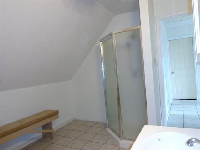 bathroom featuring tile patterned flooring, lofted ceiling, a shower with shower door, and sink