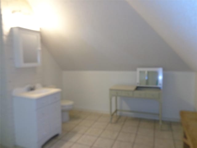 bathroom featuring tile patterned flooring, toilet, and vaulted ceiling