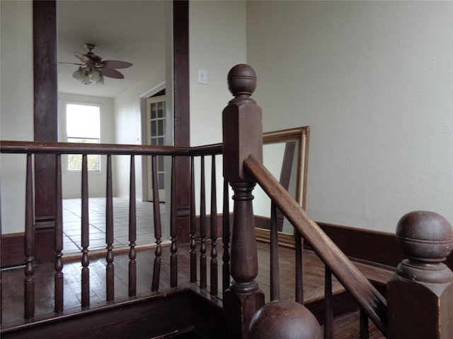 stairway with ceiling fan and hardwood / wood-style flooring