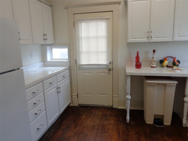 kitchen with tile counters, white cabinets, dark hardwood / wood-style floors, and white refrigerator